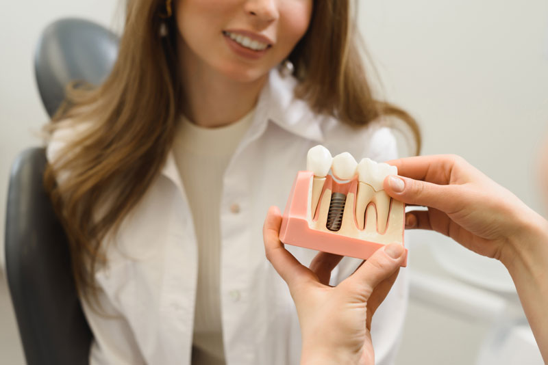 Dental Patient Getting Shown A Dental Implant Model During Her Consultation in Springfield, MO