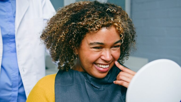 A periodontist examining a patient's mouth, focusing on the gums, using specialized dental instruments. No text on image.